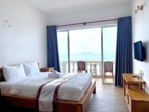 a bedroom with a bed and a view of the ocean at Sun Rose Hotel & Apartment in Xã Thang Tam