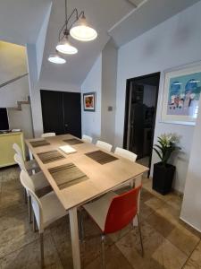 comedor con mesa de madera y sillas blancas en Hermosa casa en el centro de Zacatecas en Zacatecas