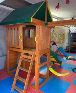 una sala de juegos con una casa en el árbol y columpios en Appartement vue sur Mer Sidi Bouzid, en Moulay Abdallah