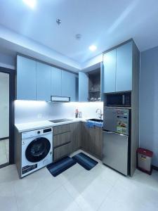 cocina con armarios azules, lavadora y lavavajillas en CSJ Dy House en Vung Tau