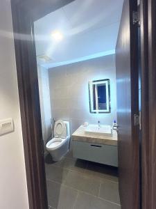 a bathroom with a toilet and a sink and a mirror at CSJ Dy House in Vung Tau