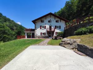 een groot wit huis bovenop een heuvel bij Chambres d'Hôtes Agorerreka in Saint-Étienne-de-Baïgorry