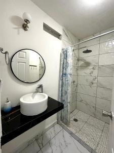 a bathroom with a sink and a shower with a mirror at Departamento Acapulco frente a la playa in Acapulco