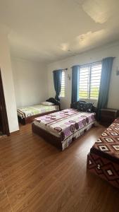 Zimmer mit 3 Betten und blauen Vorhängen in der Unterkunft Aspire Homestay in Siem Reap