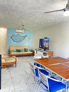 - un salon avec une table, des chaises et un canapé dans l'établissement Departamento Acapulco frente a la playa, à Acapulco