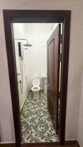 La salle de bains est pourvue de toilettes, d'une douche et d'une porte. dans l'établissement Aspire Homestay, à Siem Reap