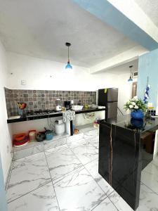 a kitchen with white marble floors and a counter top at Departamento Acapulco frente a la playa in Acapulco