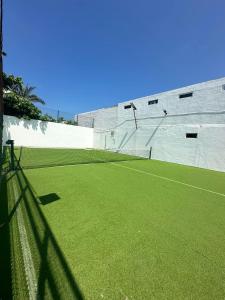 una pista de tenis con red en una pista de tenis en Departamento Acapulco frente a la playa en Acapulco