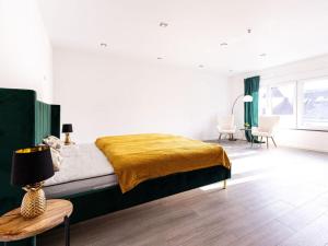 a bedroom with a bed with a yellow blanket on it at Apartment for 6 Modern retreat in Andernach