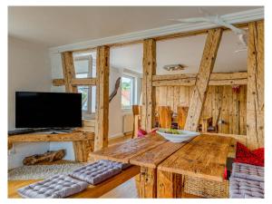 een woonkamer met een houten tafel en een televisie bij To the cuckoo Black Forest in Schonach