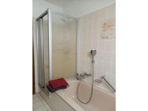 una vasca da bagno con doccia e un asciugamano rosso di Holiday apartment Mossauer Höhe a Mossautal