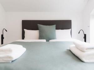 a bedroom with a large bed with two white towels at HÜSLE by UNIQUE PLACES in Bludenz