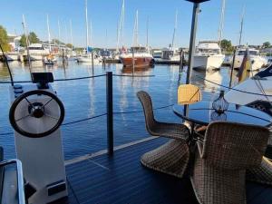 een tafel en stoelen op een steiger met boten in het water bij Ahoy Masal Modern retreat in Lübeck