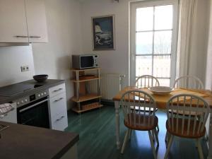 een keuken met een tafel en stoelen en een magnetron bij Sea View 3 - Villa Bella Vista in Sassnitz