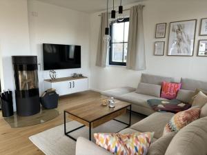 sala de estar con sofá y chimenea en Reethus in love with the sea, en Dranske