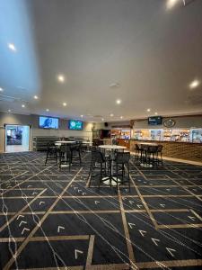 a room with tables and chairs in a library at Time and Tide Hotel Motel in Collaroy