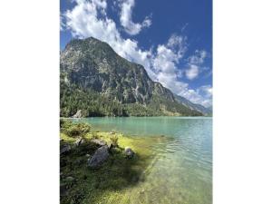 - une vue sur un lac avec une montagne en arrière-plan dans l'établissement Apart Eder Modern retreat, à Schwendau