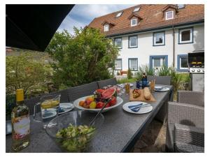 una mesa con platos de comida y una botella de vino en Historical and modern en Schonach