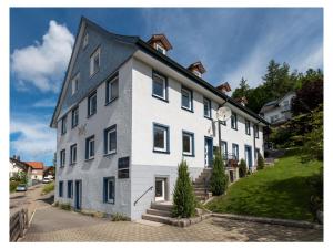 a white building with a clock on the side of it at Historical and modern in Schonach