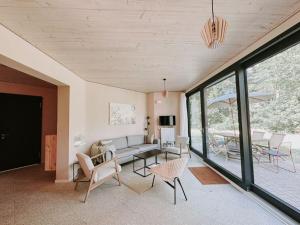 a living room with a couch and chairs and a table at Super nice holiday home by the lake in Templin