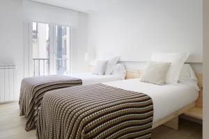 sypialnia z 2 łóżkami z białą pościelą i oknem w obiekcie Santa Maria by FeelFree Rentals w mieście San Sebastián