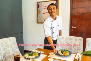 サヌールにあるTranquility Manor Baliの食卓の横に立つ男