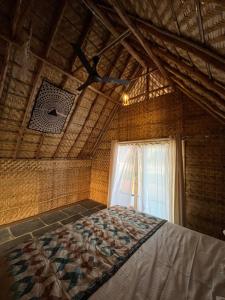 um quarto com uma cama, uma ventoinha de tecto e uma janela em Tropical Hampi em Hampi