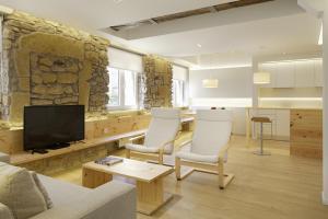 sala de estar con TV y pared de piedra. en Santa Maria by FeelFree Rentals, en San Sebastián