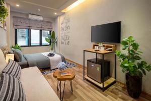 a living room with a bed and a flat screen tv at Trinh's House - Hang Vai in Hanoi