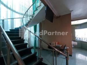 a spiral staircase in a building with a window at Nillo Hotel Kebumen Mitra RedDoorz in Kebumen