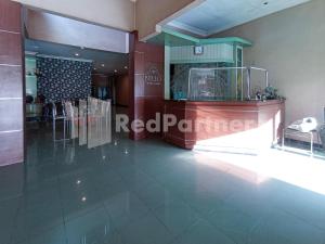 a lobby of a restaurant with a table and chairs at Nillo Hotel Kebumen Mitra RedDoorz in Kebumen