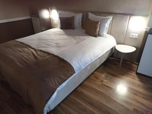 a large bed with white sheets and pillows in a room at SuiteMateo in Cluj-Napoca