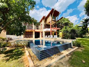 a house with a swimming pool in front of it at Amatapura Beachfront Villa 15, SHA Certified in Ao Nam Mao