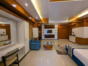 una camera d'albergo con un letto e un divano blu di Hotel Elite Palace a Comilla