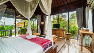 1 dormitorio con 1 cama y TV. en Umakelod Sebatu Villas, en Ubud