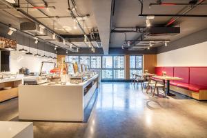 - une cuisine avec des tables et des chaises dans une pièce dans l'établissement Ramada Encore by Wyndham Kunming Guandu, à Kunming