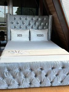 a silver bed with his hers pillows on it at Kembali coast resort A-house style in Caliclic
