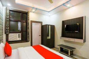 1 dormitorio con 1 cama y TV en la pared en Hotel Nimisha Jail Rd en Sītāpur