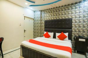 1 dormitorio con 1 cama grande con almohadas rojas en Hotel Nimisha Jail Rd en Sītāpur