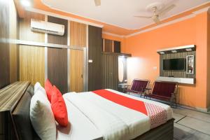 Habitación de hotel con 1 cama y 2 sillas en Hotel Nimisha Jail Rd en Sītāpur