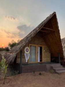 uma pequena casa com telhado de palha em Tropical Hampi em Hampi