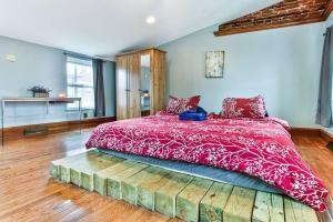 een slaapkamer met een groot bed en een rood dekbed bij *Rare* Entire Queen Village House w/ Pool Table in Philadelphia