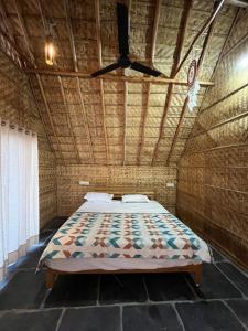 uma cama num quarto com uma ventoinha de tecto em Tropical Hampi em Hampi
