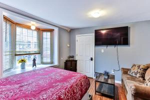 een slaapkamer met een roze bed en een bank bij *Rare* Entire Queen Village House w/ Pool Table in Philadelphia