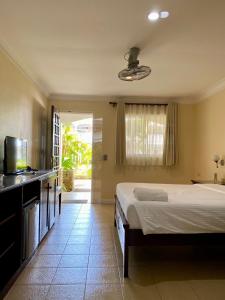 a bedroom with a bed and a flat screen tv at Panglao Regents Park Resort in Panglao Island