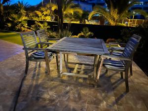 een houten tafel met vier stoelen eromheen bij Andromeda in Palm-mar