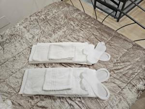 uma cama com toalhas brancas e toalhas em Casa savoia dream em Nápoles
