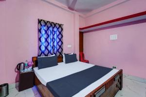 1 dormitorio con 1 cama grande y ventana en SPOT ON S Hotel & Restaurant en Patna