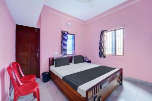 1 dormitorio con 1 cama y 1 silla roja en SPOT ON S Hotel & Restaurant, en Patna