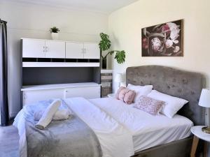 a bedroom with a large bed with white and pink pillows at Cozy Villa Near Chadstone Fashion Capital in Chadstone